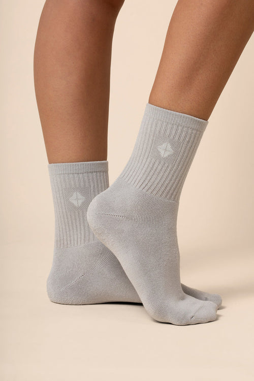 Gray socks worn by a person on a beige background