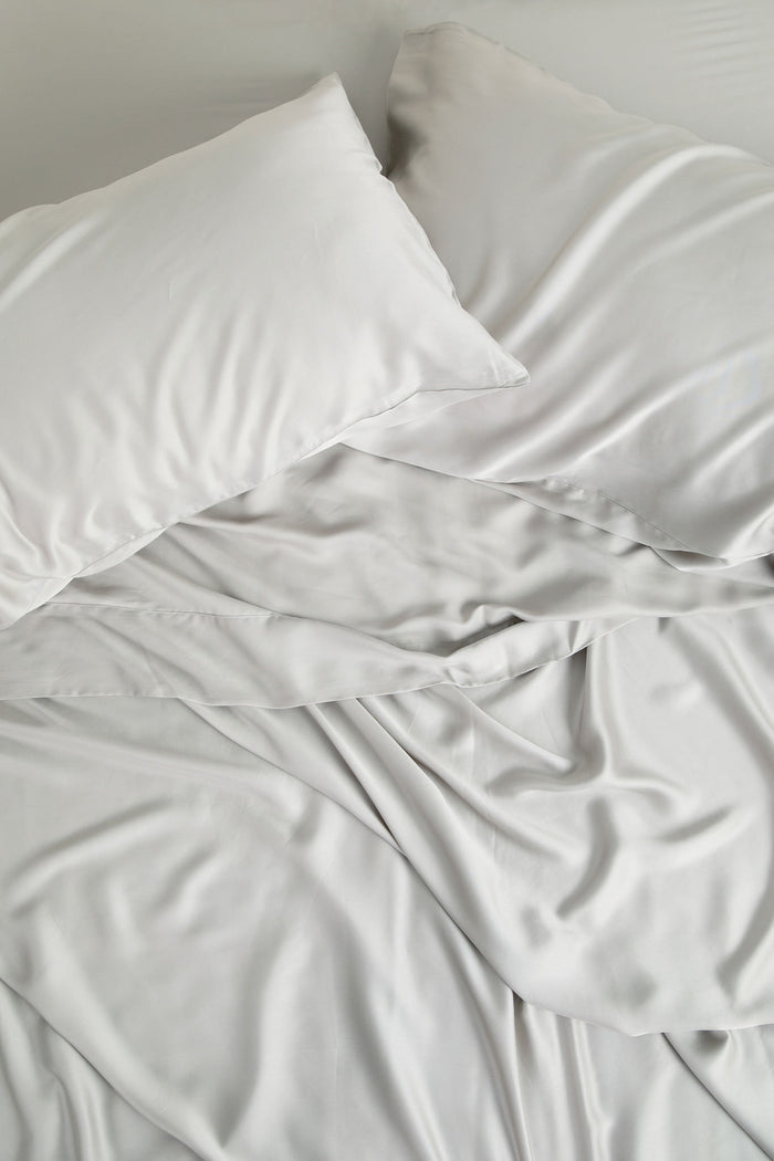 Bamboo Sateen Pillowcase Set in Dove Gray and matching bed sheets shown on a bed
