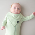 Baby wearing green bamboo bib and matching footie