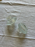 Two Busy Bees Glass Lanterns from the set of 2 displayed on textured neutral fabric with ribbed translucent glass details.