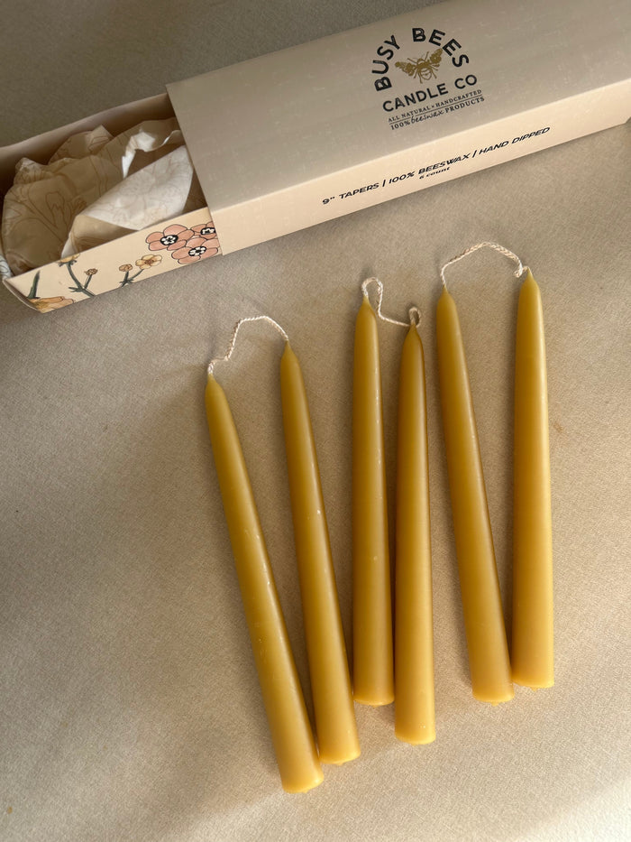 Busy Bees Hand Dipped 9 Inch Taper Candles 6 Pack arranged beside branded packaging on a soft neutral surface.