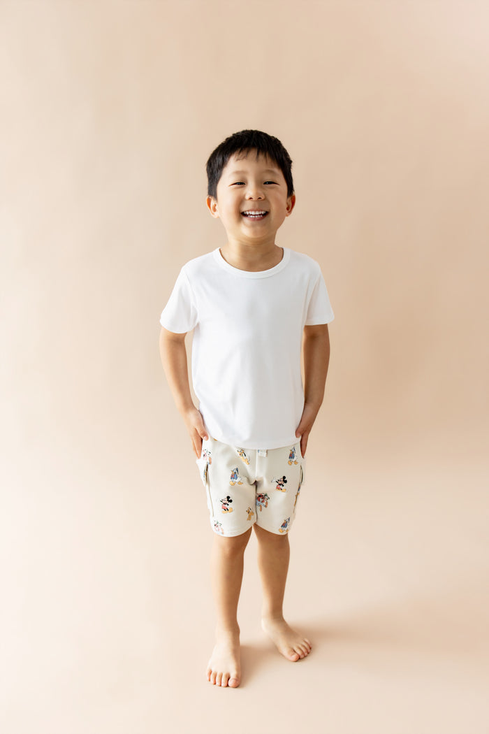 Boy child wearing white tee and mickey mouse and friends printed cargo shorts