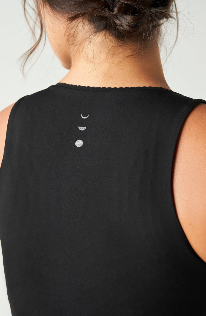 Back detail of the Elastique Athletics Adorn Tank in black highlighting the racerback design and centered logo detail.