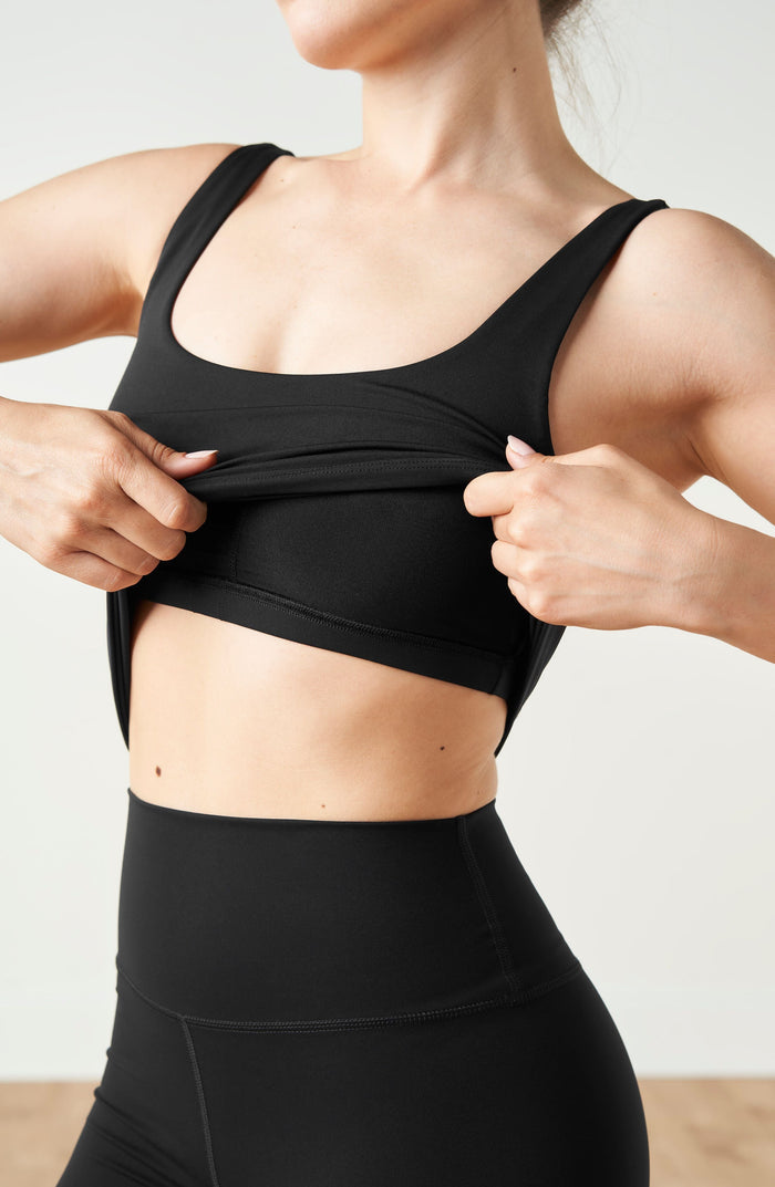 Close up detail of the Elastique Athletics Lisse Compression Tank in black showing the scoop neckline and supportive fitted design.