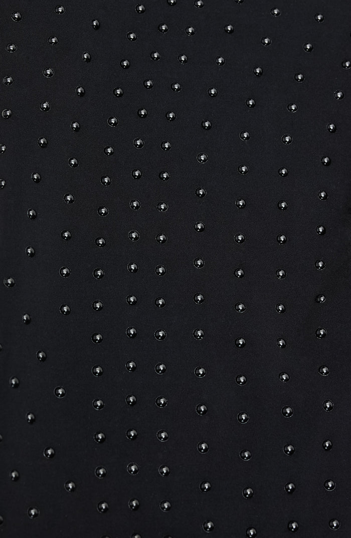 Close up fabric texture detail of the Elastique Athletics The Fierce Bra featuring a subtle dotted compression pattern on black fabric.