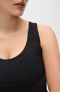 Close up detail of the Elastique Athletics The Fierce Tank in black featuring a subtle tonal leopard pattern and scoop neckline.