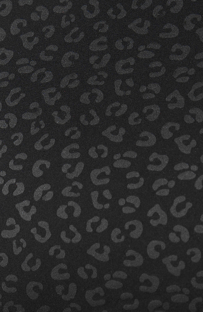 Close up fabric texture detail of the Elastique Athletics The Fierce Tank featuring a tonal black leopard print pattern.