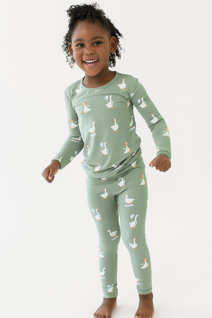 Young girl smiling wearing the Long Sleeve Pajamas in Silly Goose in front of a white backdrop
