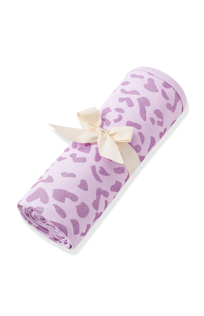 Swaddle Blanket in Thistle Leopard print rolled and packed with ribbon on white background