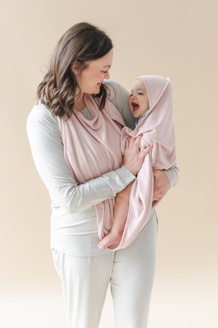 Mother holding smiling infant wrapped in the Terry Apron Towel in Blush