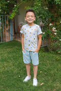 Young boy wearing a tshirt with stripes and amalfi coast inspired icons and blue shorts in an outdoor setting
