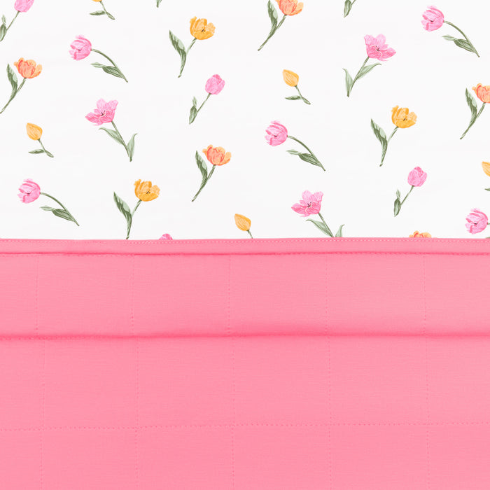 Close up of the Toddler Blanket in Tulip 1.0 showing the quilted pink backing and top floral smooth top layer
