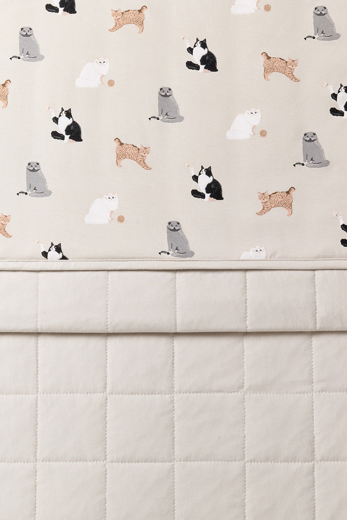 Close up of the Youth Blanket in Fluffy Cat 1.0 showing the quilted light beige backing and smooth top cat print layer